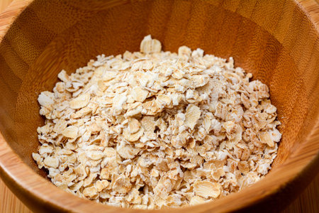Closeup for oat flakes in wooden bowl