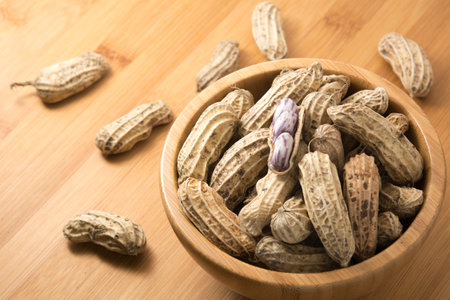 groundnut in wooden bowl and on wooden table