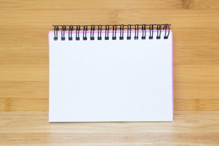 Blank paper notebook on brown wooden table background