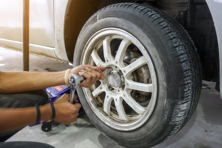Mechanician changing car wheel in auto repair shop