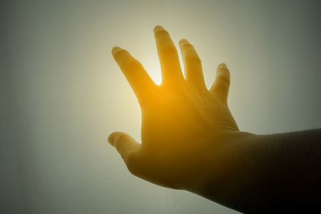 Human hand reaching for the sun - silhouetteの写真素材