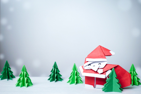 Santa claus in snowy winter background with paper cut christmas tree - closeupの写真素材