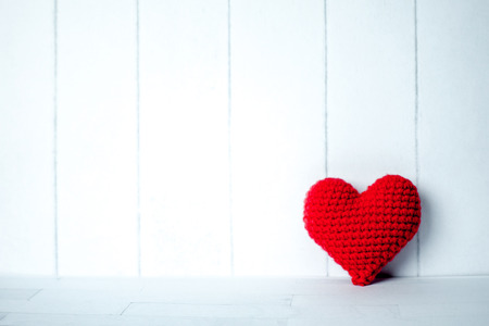 Single red heart in white room backgroundの写真素材