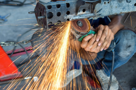 Electric wheel grinding on chassis of a car - auto body repair shopの写真素材