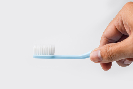 hand holding toothbrush on white background - closeupの写真素材