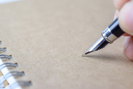Human hand signing on brown notebook - Close-upの写真素材