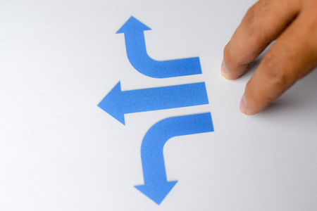 Finger standing against directions background - business conceptの写真素材