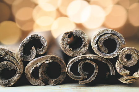 cinnamon sticks on wood with blurred lights, closeupの写真素材