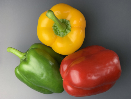 Green, yellow and red bell pepper on dark backgroundの写真素材