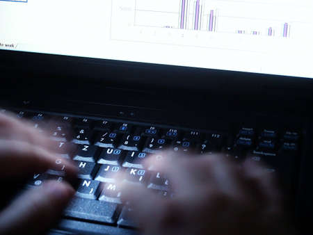 Late night work on laptop. Alight keyboard with typing handsの写真素材