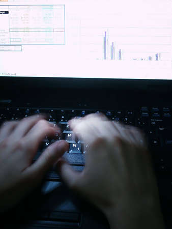 Late night work on laptop. Alight keyboard with typing handsの写真素材