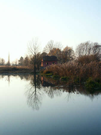 Fishkeepers house on pond during autumn with reflection.の写真素材