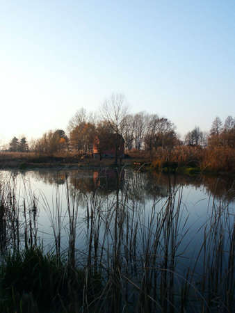 Fishkeepers house on pond during autumn with reflection.の写真素材