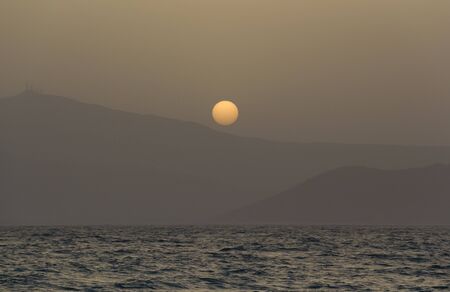 Sunset over Paros island mountains - Beautiful dreamy sunset, a view through misty air from Naxos island.の写真素材