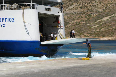Dock worker / A man is catching a rope while ship crew is standing on a docking platform of approaching ferry. Island of Sifnos, Cyclades, Greeceのeditorial素材