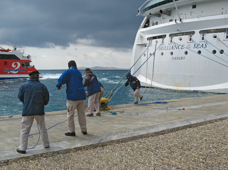 Cruiser workers. Group of people pulling the ropes of giant cruiser ship. Island of Mykonos, Cyclades, Greeceのeditorial素材