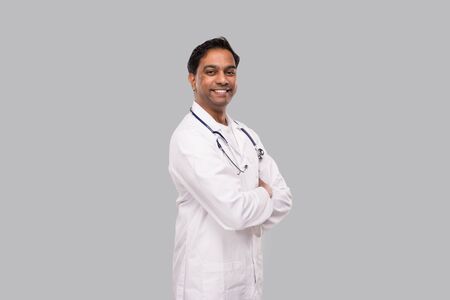 Indian Man Doctor Smiling Hands Crossed Isolated. Healthy life, Medicine Concept.の写真素材