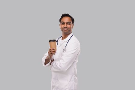Indian Man Doctor Holding Coffee Take Away Cup Smiling Isolated. Indian Doctor Holding Coffee To Go Cup.の写真素材