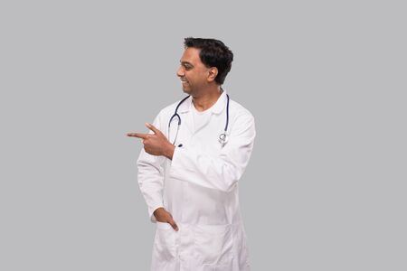 Indian Man Doctor Pointing to Side and Watching to Side. Isolatedの写真素材