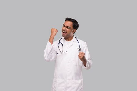 Indian Man Doctor Very Happy and Excited, Raising arms, Celebrating a Victory or Success. Winner Sign. Isolatedの写真素材