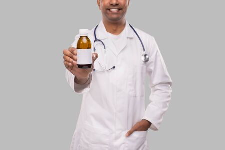 Indian Man Doctor Holding Cough Syrup Isolated Close Up. Conceptの写真素材