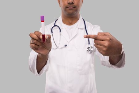Indian Man Doctor Pointing at Blood Tube Analysis Close Up. Science, Medical Concept. Isolated Doctor Serious Faceの写真素材