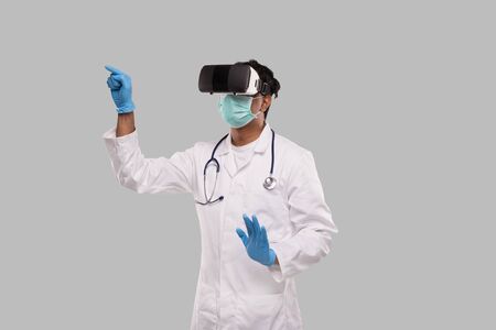 Doctor Wearing VR Glasses, Medical Mask and Gloves Tapping Isolated. Indian Man Doctor Pointing in Virtual Reality. Medicの写真素材