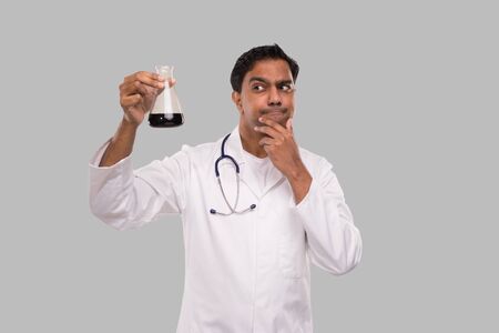 Indian Man Doctor Examing Flask with Colorfull Liquid Isolated. Medicine, Science Conceptの写真素材