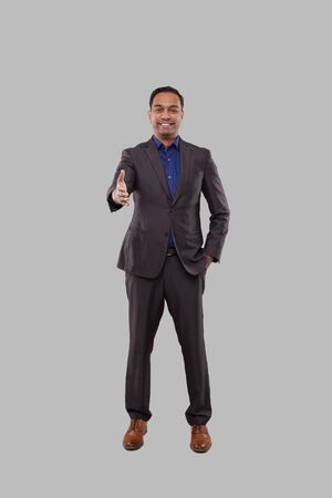 Indian Male Businessman offering hand to shake. Greeting and welcoming gesture. Business advertisement concept. Businessman Hand Shake Full Lenghtの写真素材