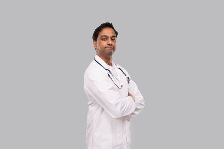 Indian Man Doctor not Smiling Hands Crossed Isolated. Healthy life, Medicine Concept.の写真素材