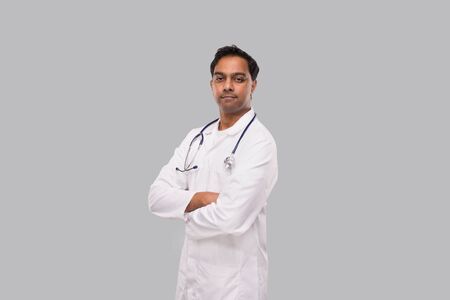 Indian Man Doctor not Smiling Hands Crossed Isolated. Healthy life, Medicine Concept.の写真素材