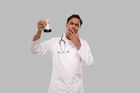 Indian Man Doctor Examing Flask with Colorfull Liquid Isolated. Medicine, Science Conceptの写真素材