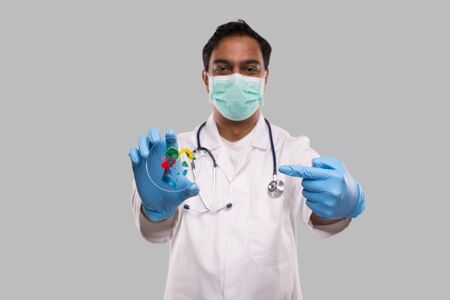 Doctor Pointing at Petri Dish Wearing Medical Mask and Gloves Isolated. Medicine, Science Conceptの写真素材