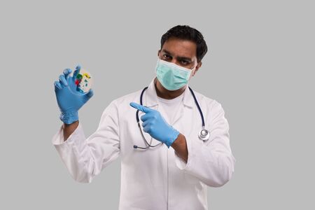 Doctor Pointing at Petri Dish Wearing Medical Mask and Gloves Isolated. Medicine, Science Conceptの写真素材