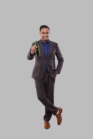 Businessman Holding Beer Bottle. Indian Businessman Standing Full Length.の写真素材