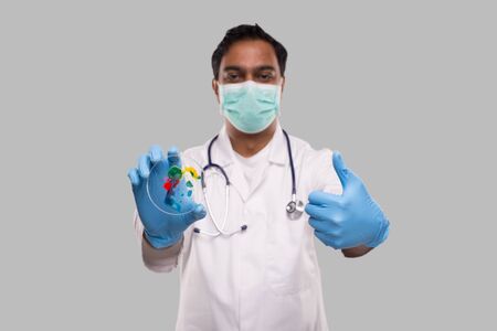 Doctor Holding Petri Dish Wearing Medical Mask and Gloves Showing Thumb up Isolated. Medicine, Science Conceptの写真素材