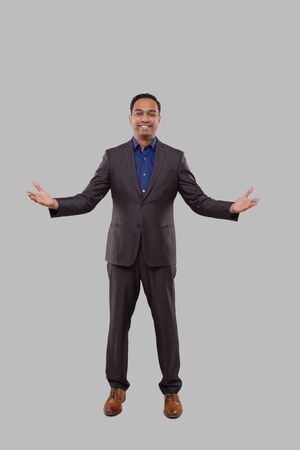 Businessman Hands To Sides Welcome Gesture Isolated. Indian Businessman Standing Full Lengthの写真素材