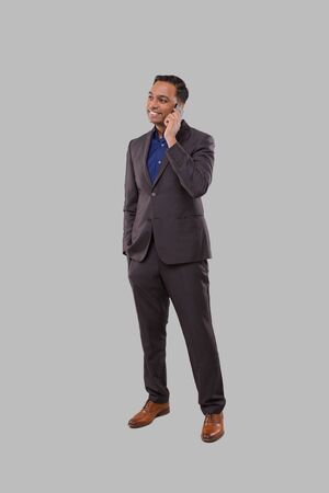 Businessman Talking on Phone Isolated. Indian Businessman Standing Full Lengthの写真素材