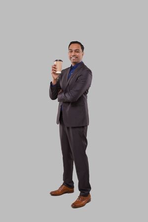 Businessman Holding Coffee To Go Cup Isolated. Indian Business man with Coffee Take Away Cup in Handsの写真素材