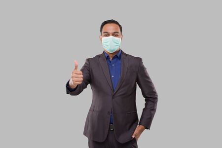 Businessman Showing Thump Up Wearing Medical Mask and Gloves Isolated. Indian Business Man Standing Thump Up signの写真素材