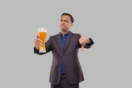 Businessman Holding Beer Glass Showing Thumb Down. Indian Business man with Beer in Handの写真素材