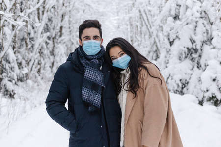Couple Wearing Medical Mask in Winter Nature. Love Story Shoot in Nature. Cute Couple, Health Care Concept. Couple in Medical Masksの写真素材