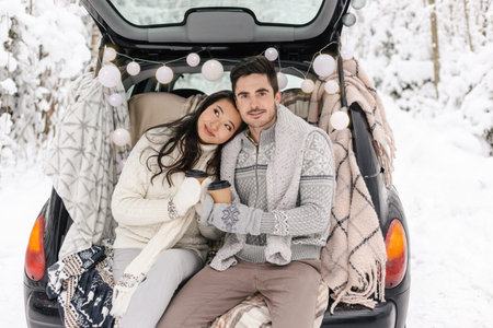 Cute Couple Having Winter Forest Picnic Drinking Tea from Tea Take Away Cup. Nature Picnic. Love...