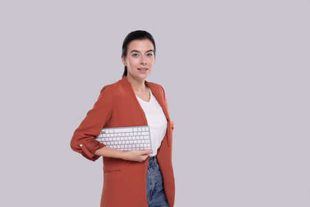 Girl Office Worker Holding Keyboard in Hands Girl Isolatedの写真素材