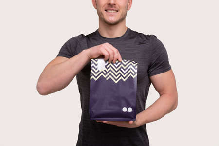 Sport Man Holding Sport Food. Sportsman Holding Protein Pack Close Upの写真素材