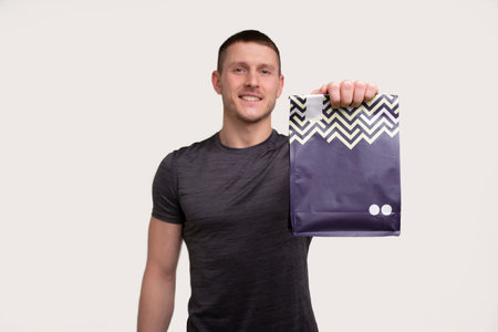 Sport Man Showing Sport Food. Sportsman Holding Protein Packの写真素材