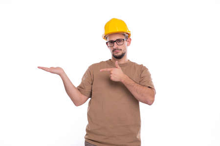 Builder Holding Hand to Side Pointing at It Isolated. Man Construction Worker Sign. Advertisment, Commercial, Business conceptの写真素材