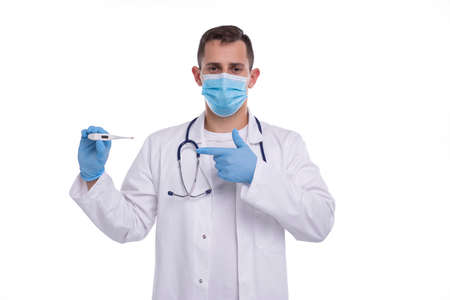 Doctor Showing Thermometer Wearing Medical Mask and Gloves Pointing at It Isolated. Man Doctor with Thermometer in Hands. Healthy Life, Doctor, Virus Conceptの写真素材