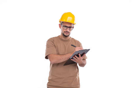 Man Construction Worker Writing in Clipboard Watching in Camera Isolated. Man Builder Working with Clipboard. Commecial, Shopping, Advertisment Conceptの写真素材
