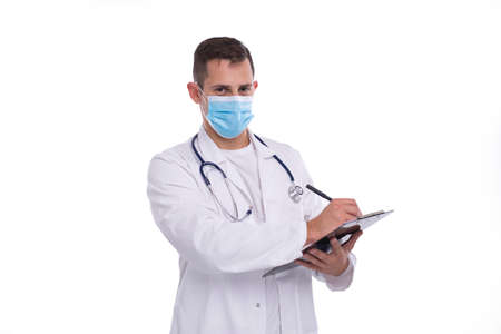 Doctor Man Writing in Clipboard Wearing Medical Mask Isolated. Doctor Working with Clipboard. Commecial, Shopping, Advertisment Conceptの写真素材